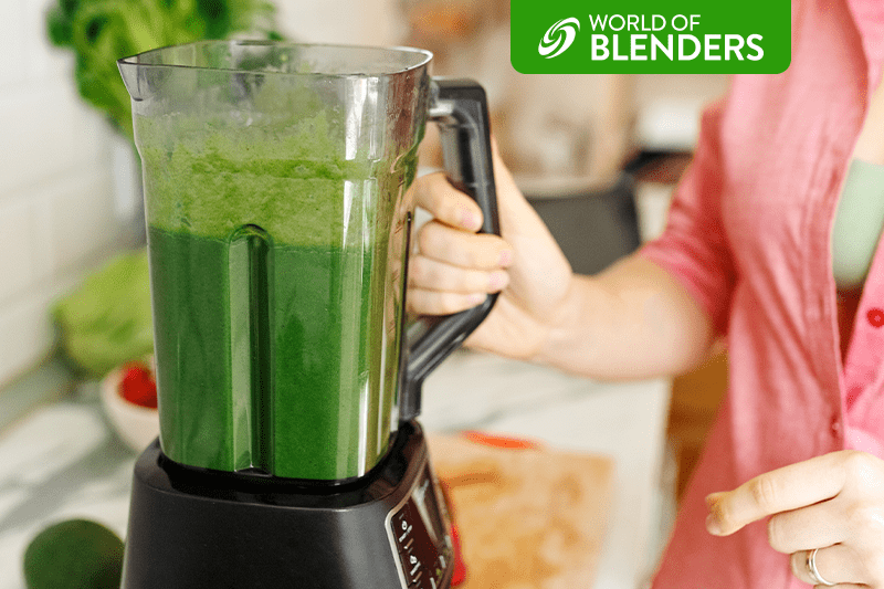 woman blending a green smoothie