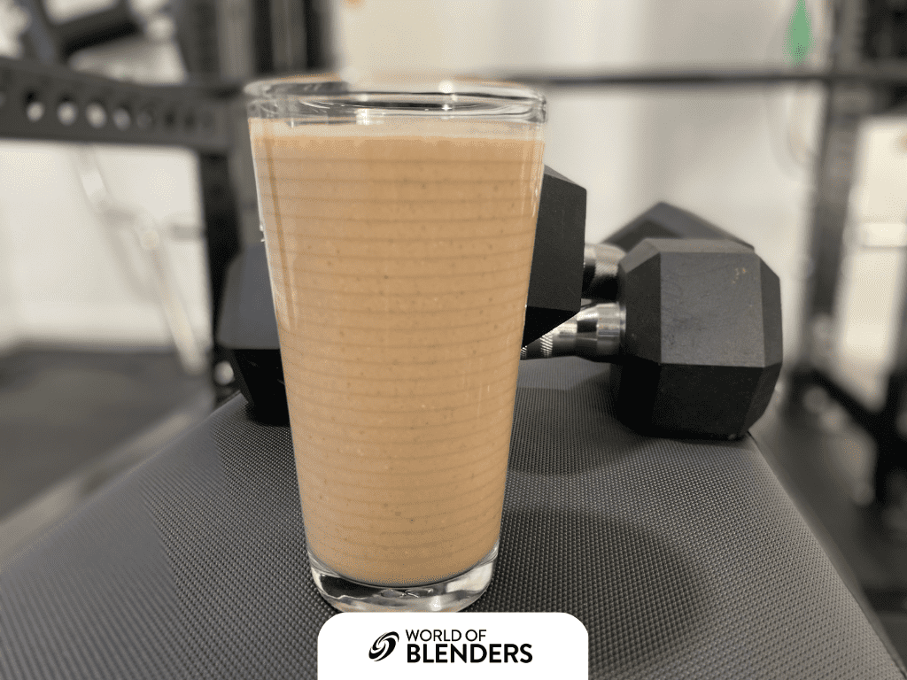 protein shake in a glass with weights behind it