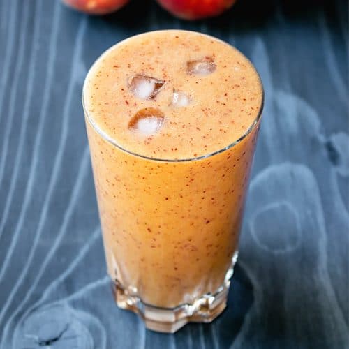 banana peach smoothie on a blue wood counter