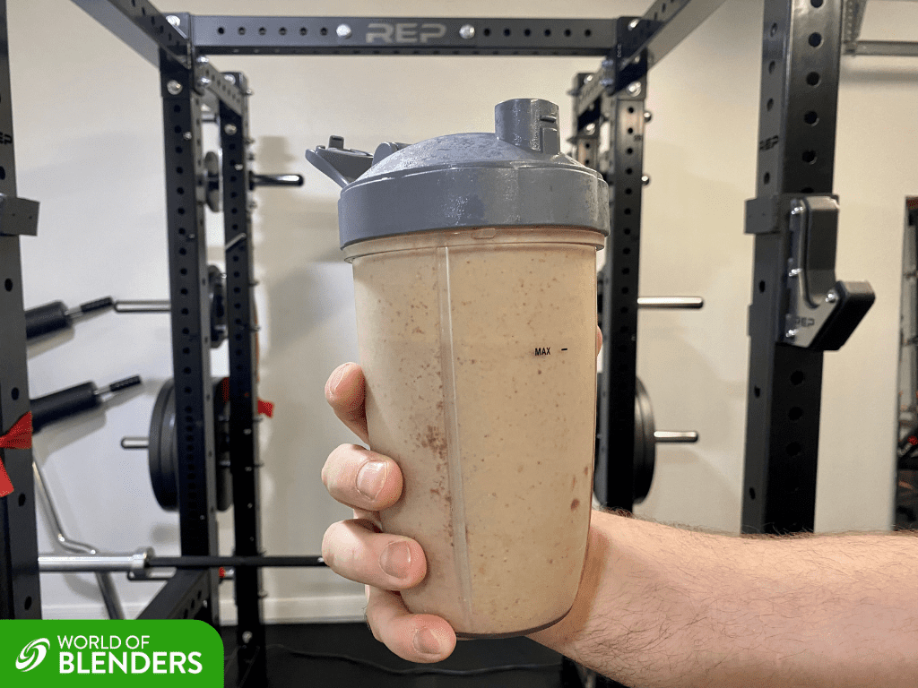 protein shake in a shaker bottle with gym rack in the background