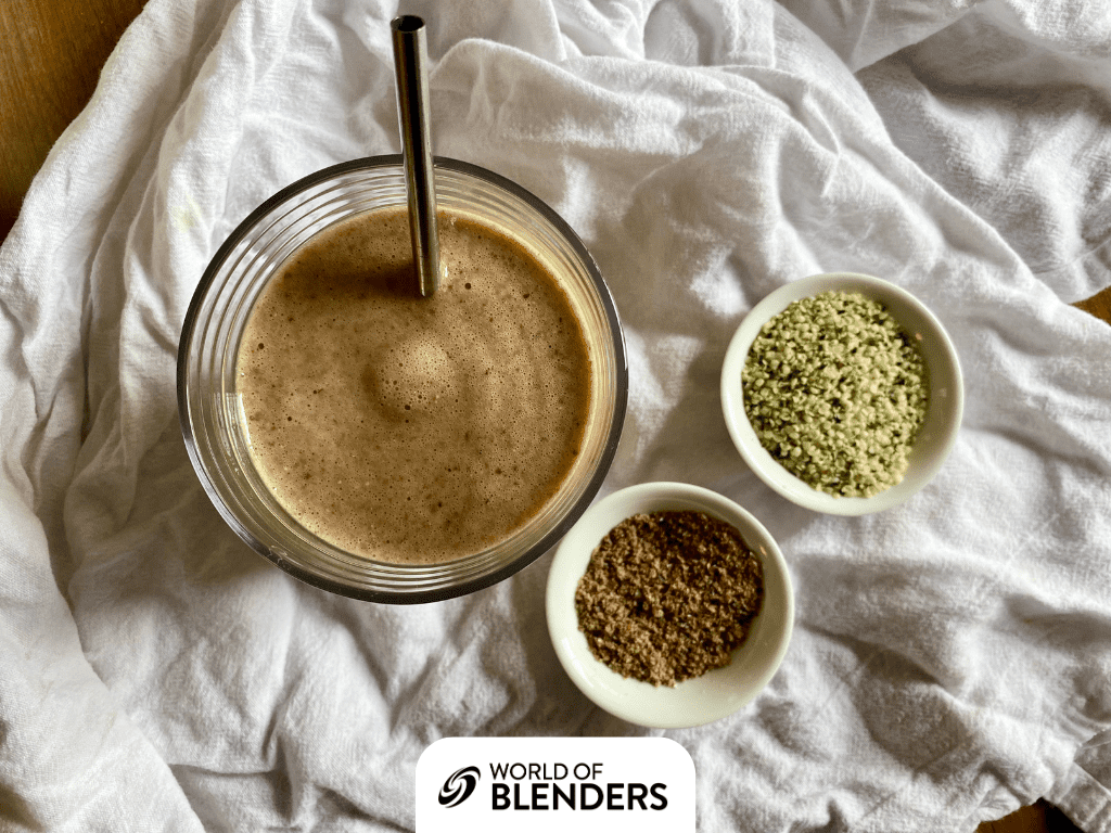 top view smoothie next to bowls of flax seeds and hemp seeds