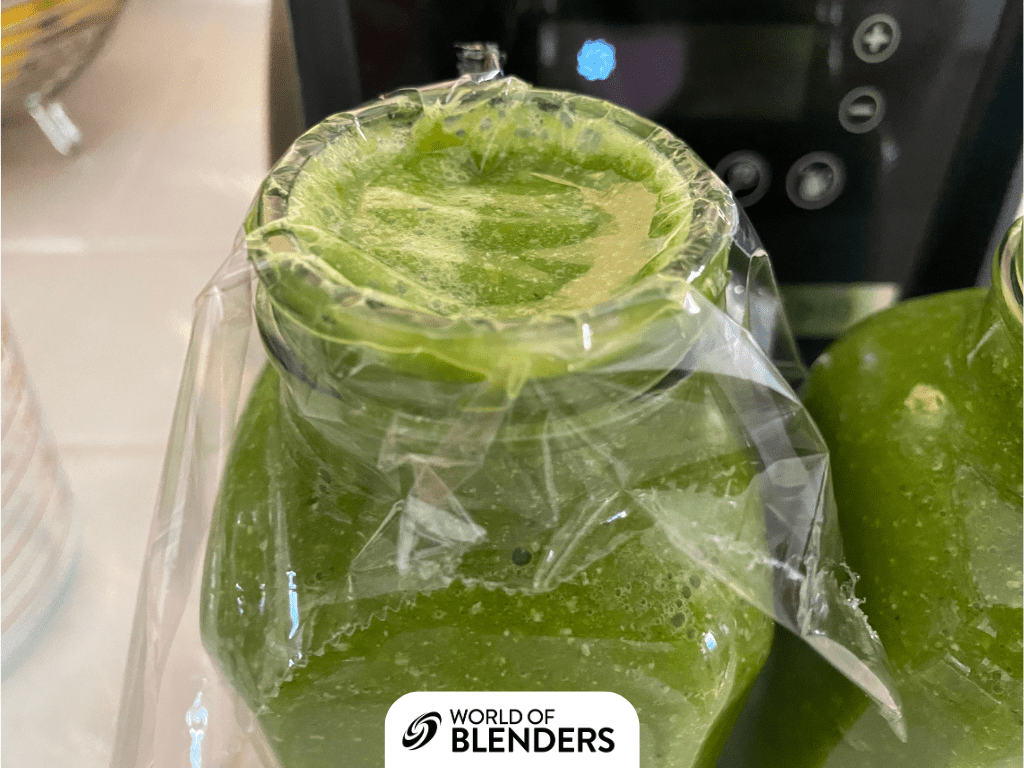 green smoothie covered with plastic  wrap to keep air out