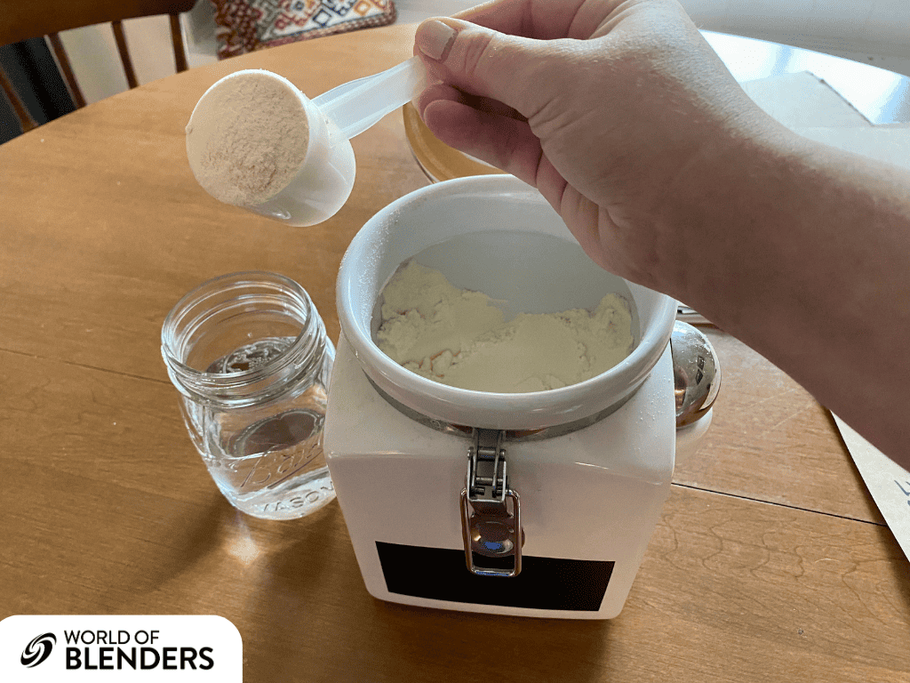 pouring vanilla protein powder in a glass jar of water