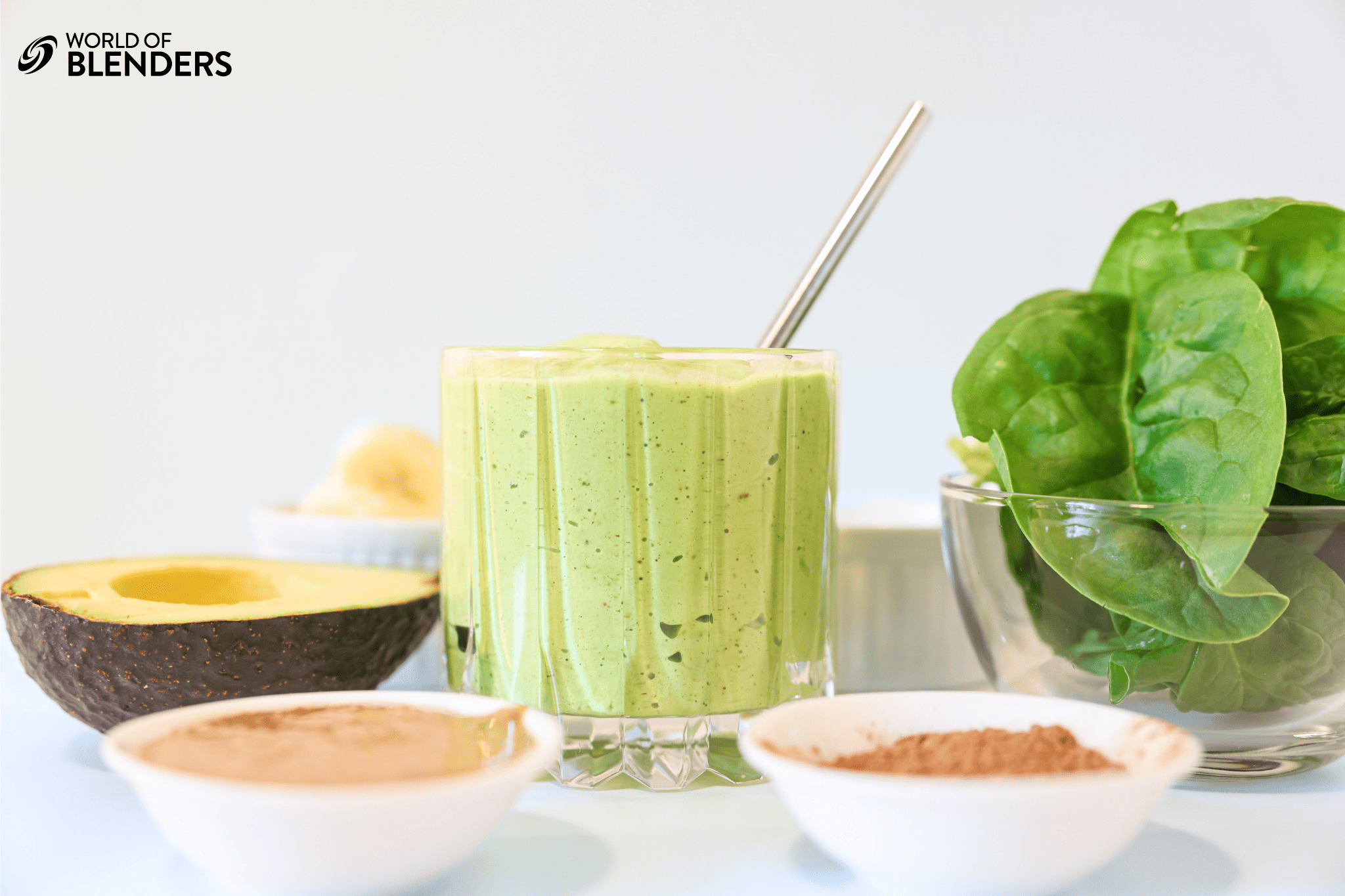 spinach avocado smoothie with ingredients around it